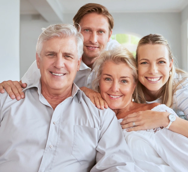 Smiling multi-generational family embracing indoors, representing the team behind Goodshine Dental