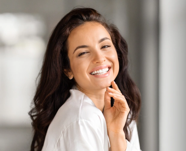 Smiling woman with a bright, white smile, representing cosmetic dentistry results