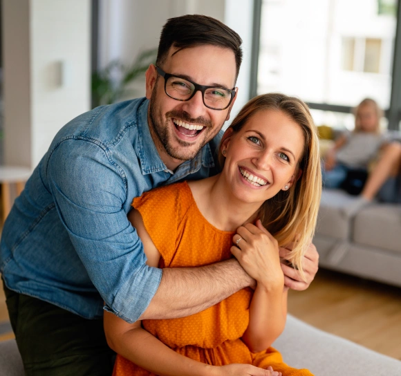 Happy couple embracing at home, representing preventive dentistry for the whole family
