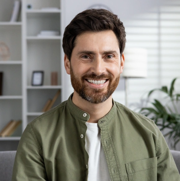 Smiling man in a green shirt, representing a teeth whitening patient